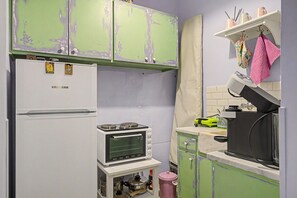 Een keuken met een koelkast, oven, spoelbak en magnetron.