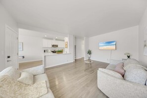 Un salon moderne avec un canapé, une petite table d’appoint et un tableau accroché au mur.