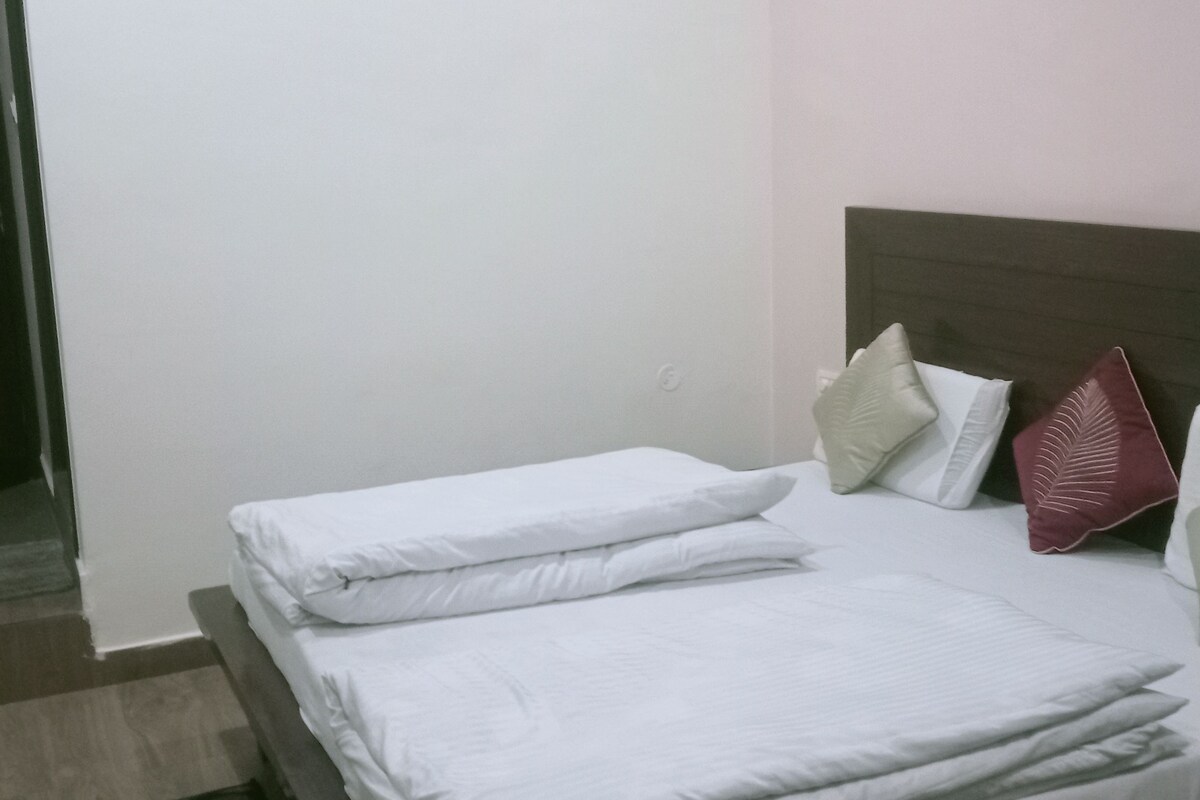 Una habitación de hotel con cama, almohadas y una puerta.