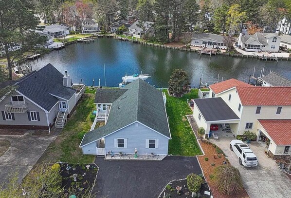 A residential area with houses, a dock, and a body of water. - Spacious canal-front home with private dock, parking, and family-friendly amenities. (Ocean Pines)