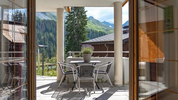 A balcony with a table and chairs, a potted plant, and a view of mountains. - Valletta Appartement/Fewo, Dusche oder Bad, WC, 6-Bettwohnung by Interhome (Arosa)