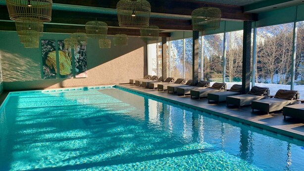 A swimming pool with lounge chairs and wicker ceiling lights. - Rothornblick 19 Appartement/Fewo, Bad, WC, 3-Bettwohnung Rothornblick 19 by Interhome (Arosa)