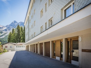 A hotel with a row of rooms, a covered walkway, and a mountain backdrop. - Waldhof 4 by Arosa Holiday Appartement/Fewo, Dusche, WC, 2-Bettwohnung Waldhof 4 by Interhome (Arosa)