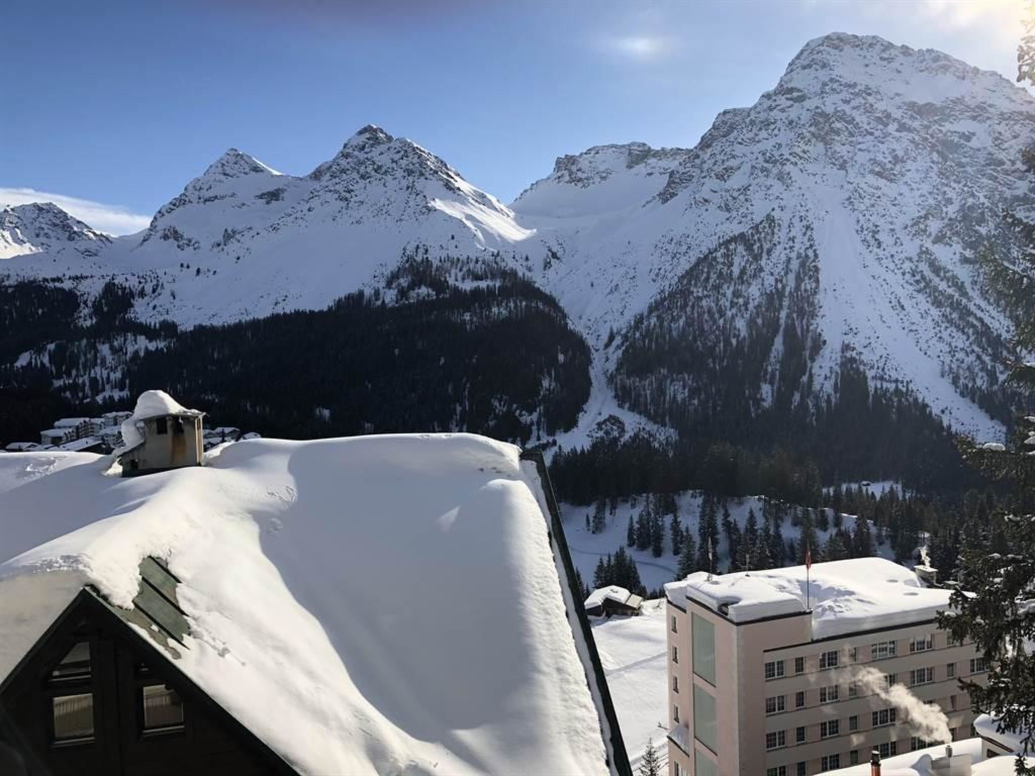 Un paysage montagneux enneigé avec des bâtiments.