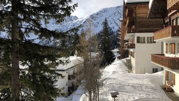 A snow-covered mountain landscape with a building featuring balconies and a snow-covered roof.
