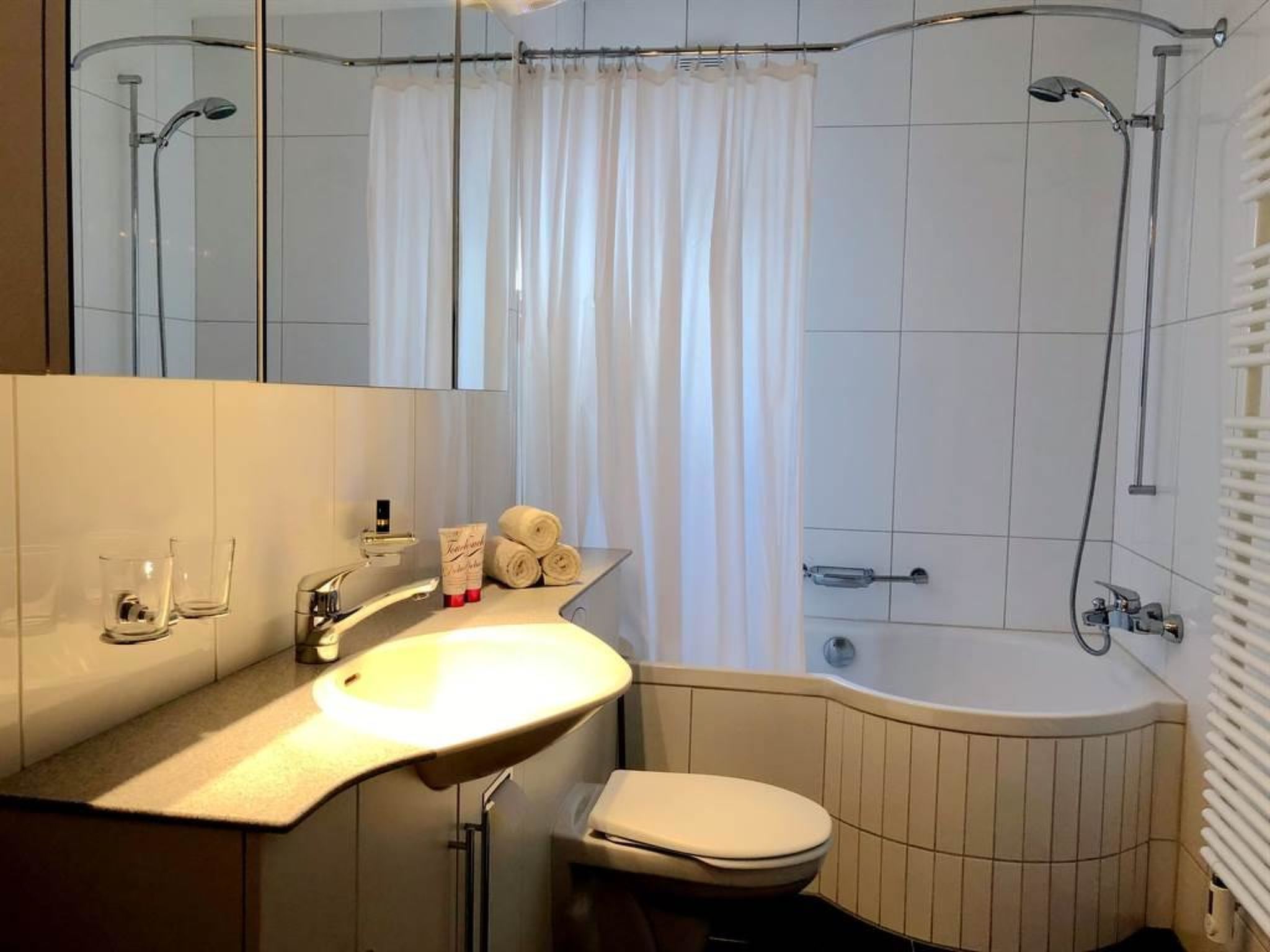 A modern bathroom with a bathtub, a toilet, a sink, and a shower.