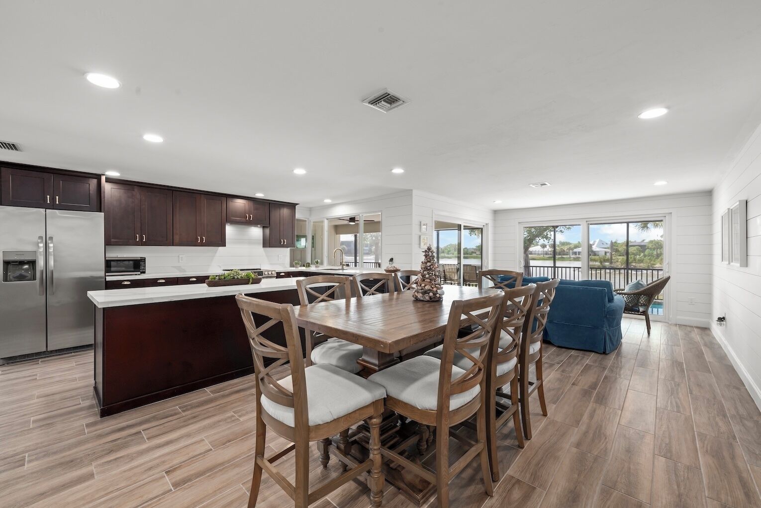 Une cuisine moderne avec un îlot central, des chaises en bois et une table à manger.