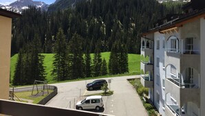 Blick auf einen Berg mit einem Gebäude, einem Parkplatz und einer Schaukel.