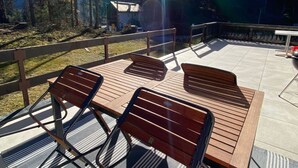 Eine Terrasse mit Sitzgelegenheiten, im Hintergrund Berge und ein klarer Himmel.