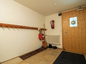 A hallway with a coat rack, a fire extinguisher, a radiator, and a door with a window. - Bella Riva by Arosa Holiday Appartement/Fewo, Dusche oder Bad, WC, 5-Bettwohnung by Interhome (Arosa)