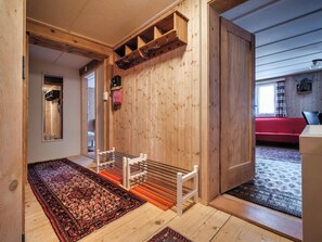 A wooden interior with a bench, a red sofa, and a patterned rug. - Nühus 1. OG Appartement/Fewo, Bad, WC, 6-Bettwohnung by Interhome (Arosa)