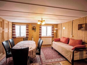 A cozy room with a wooden interior, a dining table with chairs, a sofa, and a radiator. - Nühus 1. OG Appartement/Fewo, Bad, WC, 6-Bettwohnung by Interhome (Arosa)