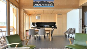 A modern interior with a kitchen, dining area, and seating. - Erzhornblick Appartement/Fewo, Dusche und Bad, WC, 3 Schlafräume by Interhome (Arosa)