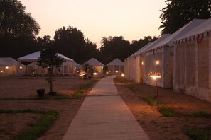 A row of tents with a pathway between them. - Kumbh Ganga Retreat (Nashik)