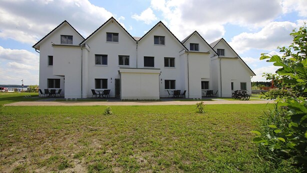 Un grande edificio a più piani con una facciata simmetrica, numerose finestre e un ingresso centrale.