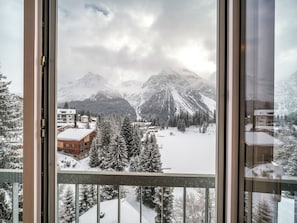 Eine verschneite Berglandschaft mit Gebäuden und Bäumen.