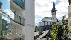 Un edificio moderno con una insegna che recita 'VIKTORIA' e una chiesa con una torre dell'orologio sullo sfondo.