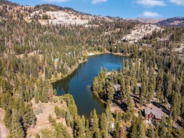 Una cabaña apartada rodeada de un bosque frondoso y un lago.