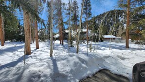 A snow-covered landscape with tall trees and a building in the background. - Quiet Keystone Condo Near Slopes, Lake Dillon, Pool and Hot Tub (Keystone)