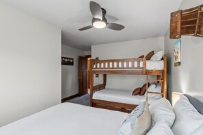 A bunk bed room with a ceiling fan, a door, and a wall-mounted sign. - Quiet Keystone Condo Near Slopes, Lake Dillon, Pool and Hot Tub (Keystone)