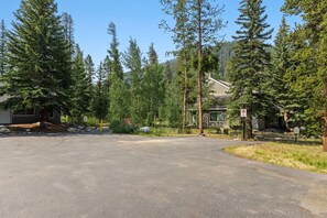 A residential driveway with a no parking sign, surrounded by tall evergreen trees and a house with a visible garage. - Quiet Keystone Condo Near Slopes, Lake Dillon, Pool and Hot Tub (Keystone)