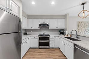 A modern kitchen with stainless steel appliances, white cabinetry, and a wooden floor. - Quiet Keystone Condo Near Slopes, Lake Dillon, Pool and Hot Tub (Keystone)
