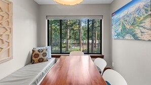 A room with a large window, a wooden table, and a bench with pillows. - Quiet Keystone Condo Near Slopes, Lake Dillon, Pool and Hot Tub (Keystone)