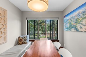A room with a large window, a wooden table, and a bench with pillows. - Quiet Keystone Condo Near Slopes, Lake Dillon, Pool and Hot Tub (Keystone)