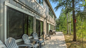 A building with large windows, outdoor seating with chairs, and a pathway leading to the building. - Quiet Keystone Condo Near Slopes, Lake Dillon, Pool and Hot Tub (Keystone)
