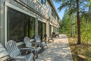 A building with large windows, outdoor seating with chairs, and a pathway leading to the building. - Quiet Keystone Condo Near Slopes, Lake Dillon, Pool and Hot Tub (Keystone)