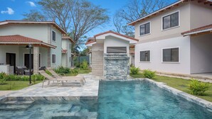 A residential property with a swimming pool, two-story houses, and a patio area.