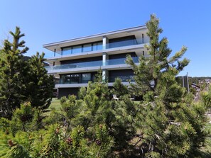 A multi-story building with a modern architectural design, featuring balconies and large windows. - Eden 3 by Arosa Holiday Appartement/Fewo, Bad, WC, 6-Bettwohnung by Interhome (Arosa)