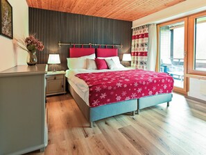 A bedroom with a bed, bedside tables, a nightstand, a window with curtains, and a view of the outdoors. - I dr Rehwiesa A25 Appartement/Fewo, Bad, WC, 3-Bettwohnung by Interhome (Arosa)
