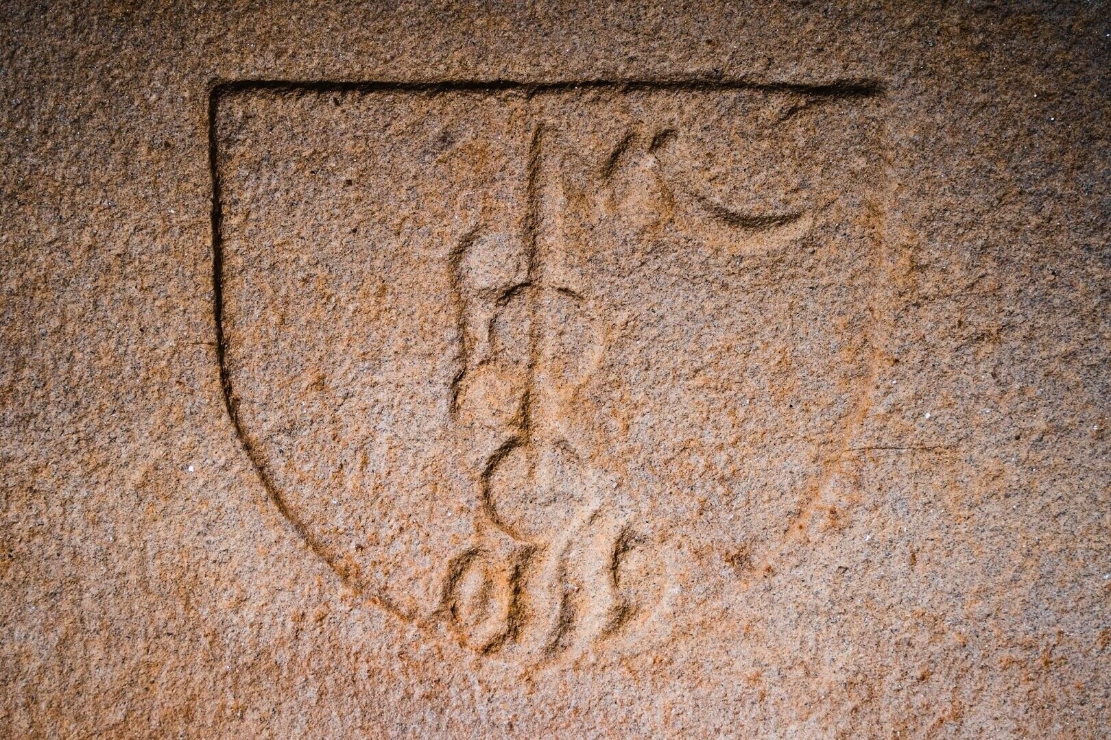 Una piedra con un escudo tallado.
