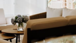 Una sala de estar moderna con un sofá, una mesa de centro y un jarrón de flores.