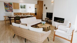 Una sala de estar moderna con sofá, sillas, una mesa de centro y una chimenea.