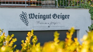 A sign with the name 'Weingut Geiger' and a grape cluster symbol. - Apartment 'Haus 4, 2-Zimmer' with Lake View, Shared Terrace and Wi-Fi (Meersburg)