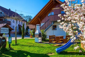 Ein Holzgebäude mit einer blauen Rutsche, einem Grillplatz und einem Schild, das ein Weingut anzeigt.