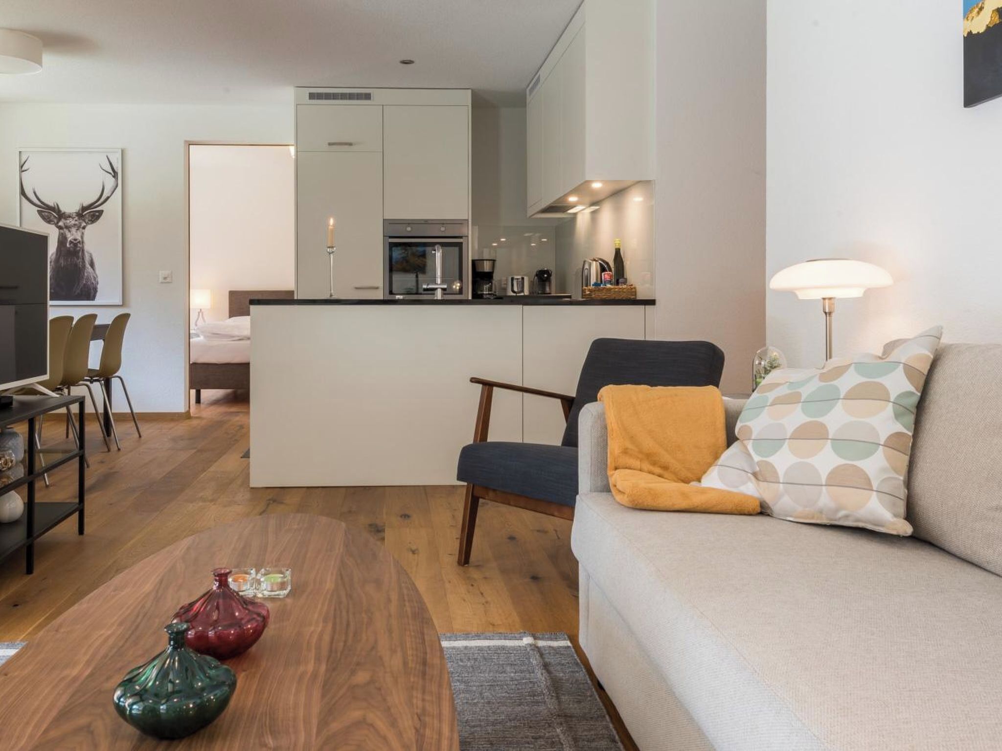 Una sala moderna con sofá, una mesa de centro y un comedor con sillas.