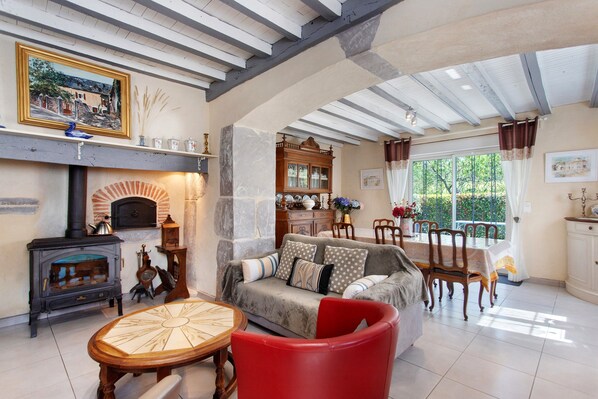 A spacious living room with a fireplace, a dining area, and a view of the outdoors.