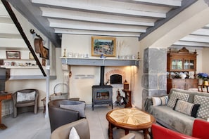 A cozy living room with a fireplace, a sofa, a coffee table, and a television.