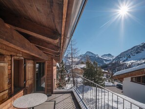 A wooden balcony with a view of snow-covered mountains and a clear sky. - Chalet Höckli 1 Appartement/Fewo,  , 6-Bettwohnung 6-Bettwohnung by Interhome (Arosa)