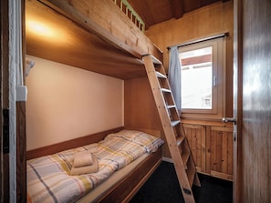 A bunk bed with a ladder, a window with curtains, and a door. - Chalet Höckli 1 Appartement/Fewo,  , 6-Bettwohnung 6-Bettwohnung by Interhome (Arosa)