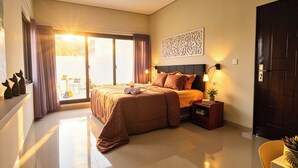A bedroom with a bed, a nightstand, a wall-mounted light, a decorative panel, and a sliding door to a balcony. - dParis Villas Ubud (Bali)