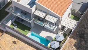 Un immeuble résidentiel moderne à plusieurs étages, doté d’une piscine sur le toit, d’un espace extérieur aménagé et d’un jardin bien entretenu.