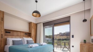 Une chambre moderne avec un grand lit, une porte-fenêtre coulissante donnant sur un balcon et une vue sur le paysage.
