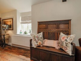 Una habitación tradicional con un banco de madera, un radiador, una ventana con vistas y un cuadro en la pared.