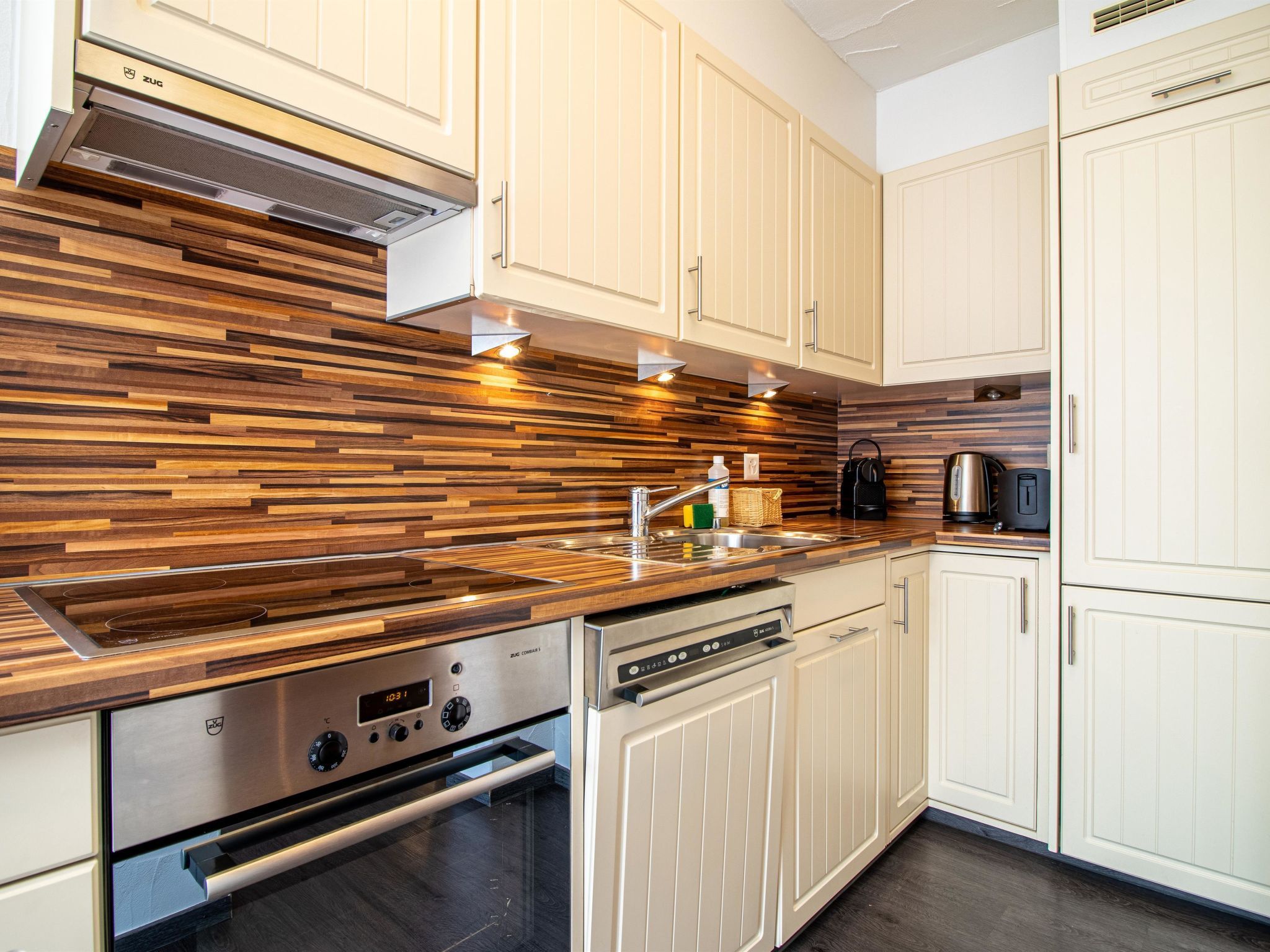 Eine moderne Küche mit Holzverkleidung, Edelstahlgeräten und weißen Schränken.