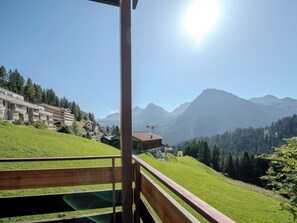 A hotel with a view of mountains and a grassy hill. - Marlenca 2 by Arosa Vacations Appartement/Fewo, Dusche und Bad, WC, 2 Schlafräum by Interhome (Arosa)