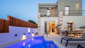 Um edifício moderno com piscina, área de estar externa e varanda.